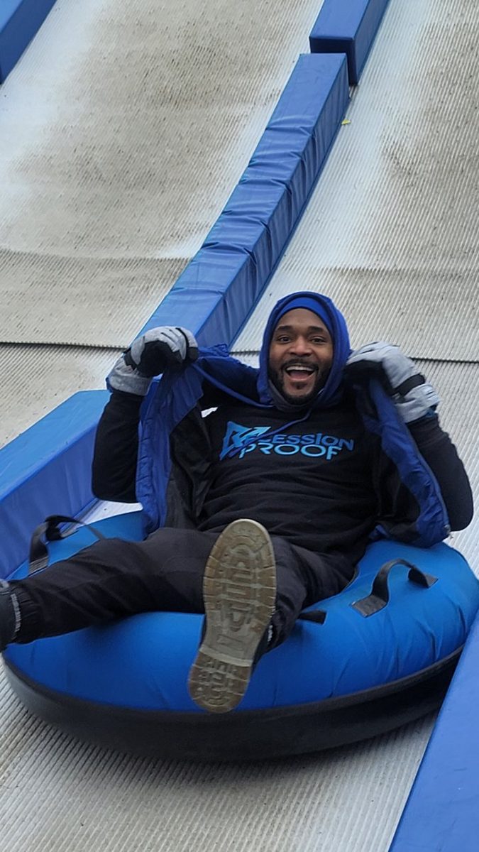Jermaine on a snow tube in his Recession Proof shirt at the chapter's first-anniversary winter outing in downtown Detroit, December 2022.